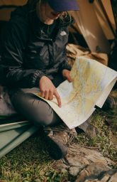 photo-of-woman-sitting-while-pointing-on-world-map-2422483